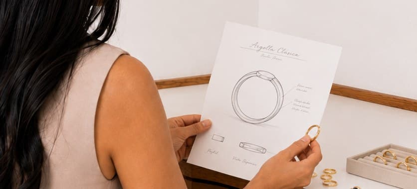 Helen revisando un boceto de la Argolla Clásica, con anillos Nhia sobre la mesa