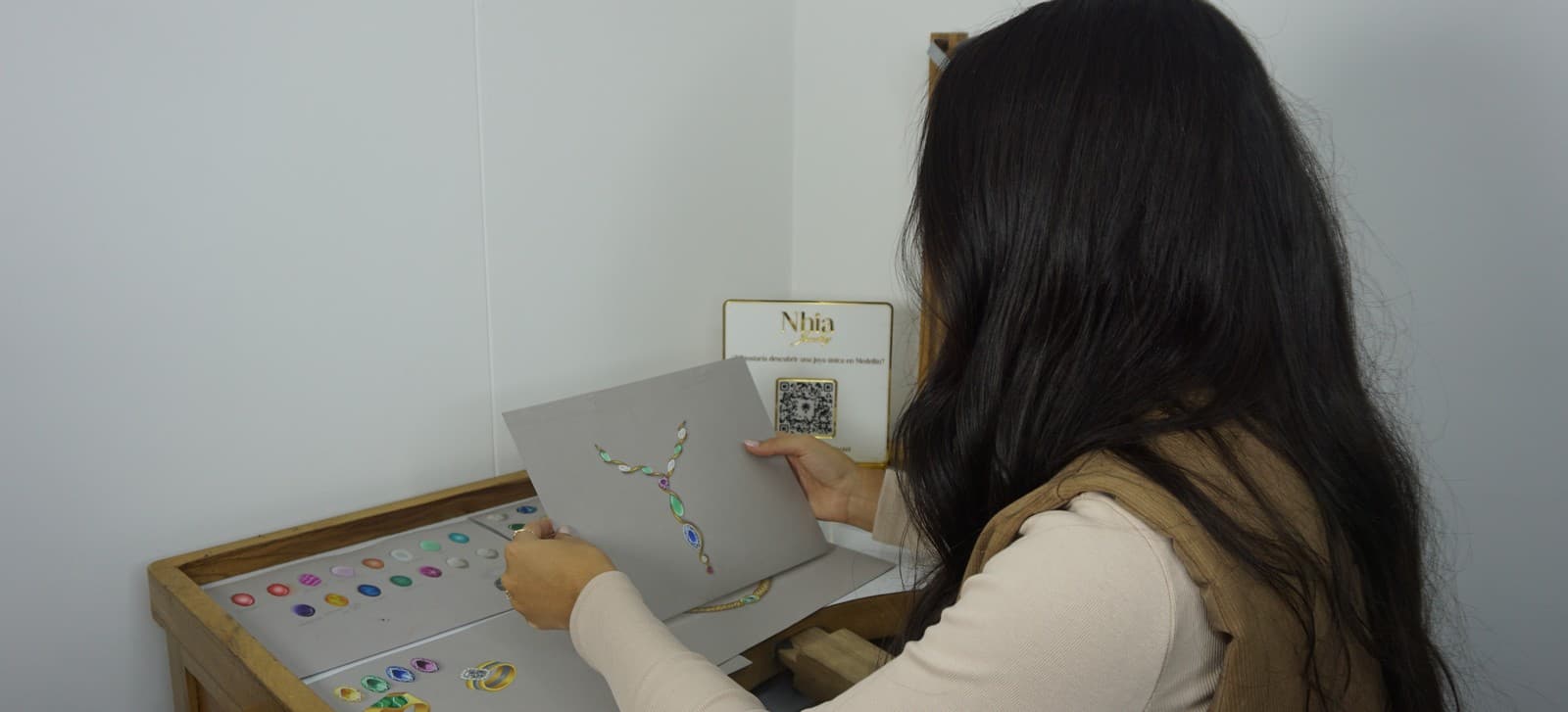 Helen revisando un boceto de la Argolla Clásica, con anillos Nhia sobre la mesa